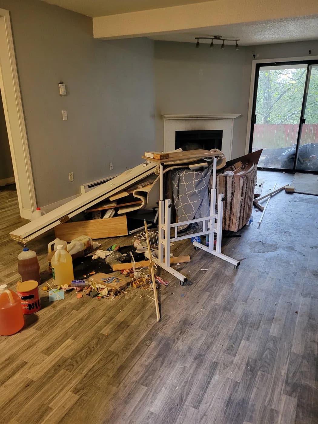 Furniture parts, boards and carpet remnants piled in a living room before a ZipHaul cleanout